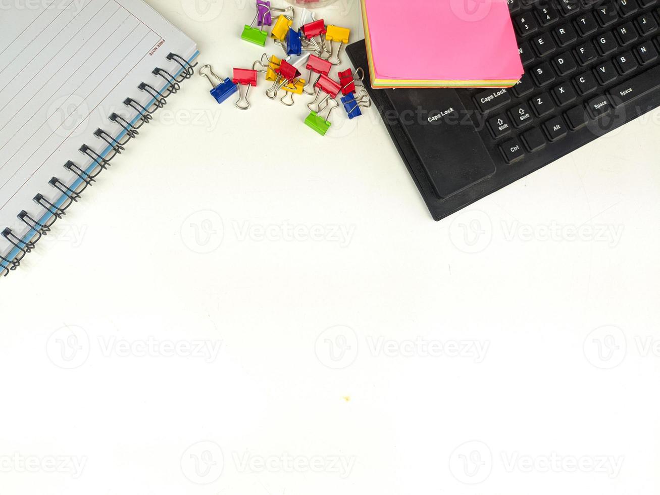 escritorio blanco plano en la oficina con espacio de diseño.con equipo de oficina como lápices, cuadernos y teclados en la parte superior.mesa simulada foto