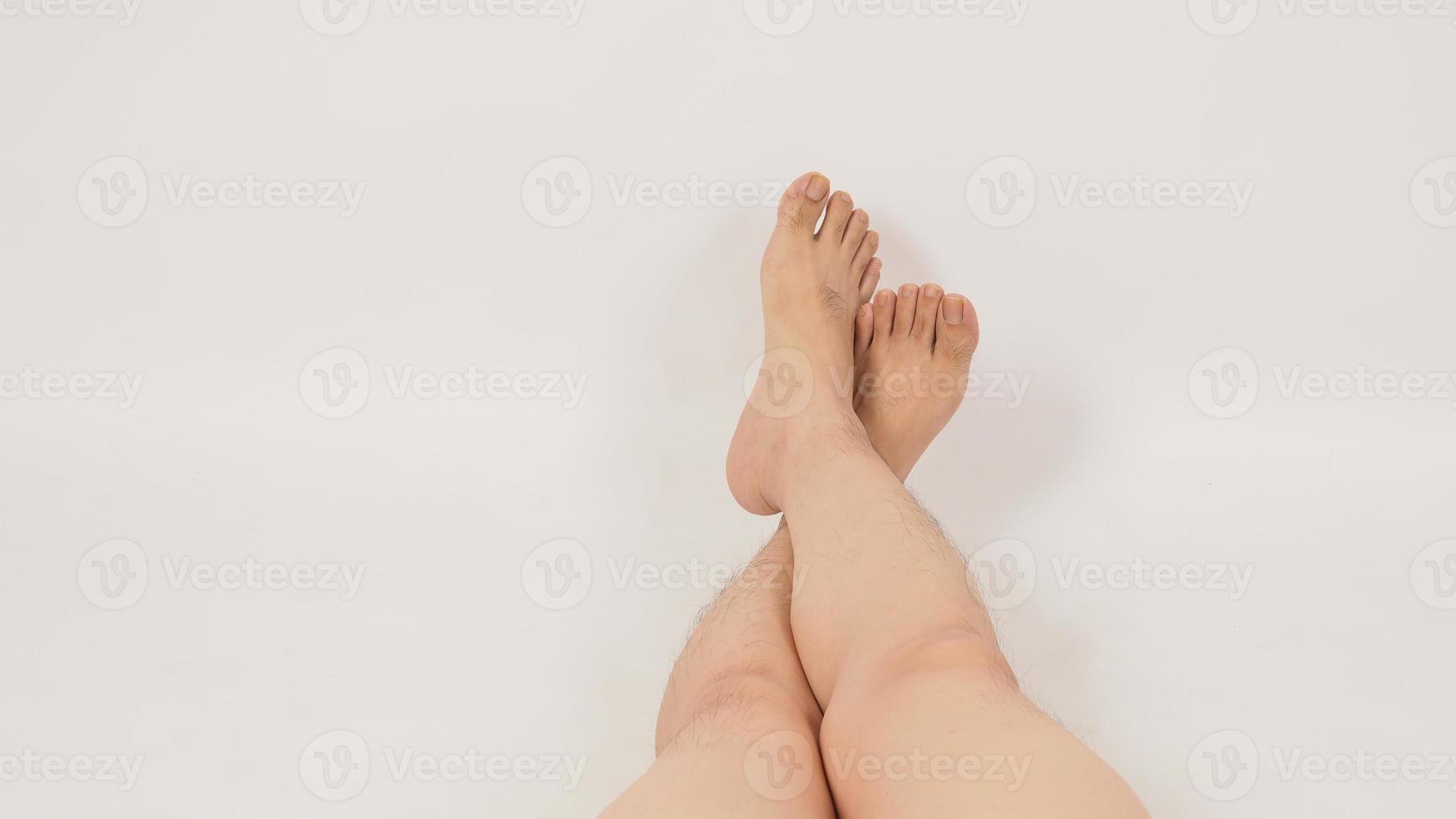 Asian man is lie down with legs and barefoot on white background. photo