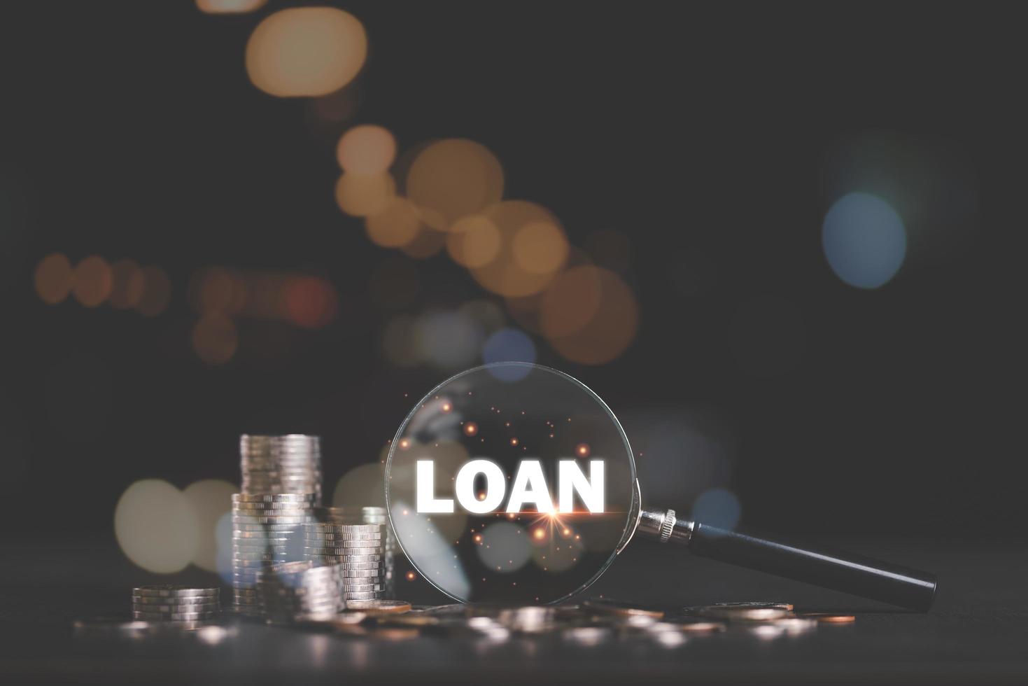 Stacks of coins and a magnifying glass on the table,investment loan concepts to build a residential home,real estate business,investment savings,mortgage and bank loans,future retirement planning photo