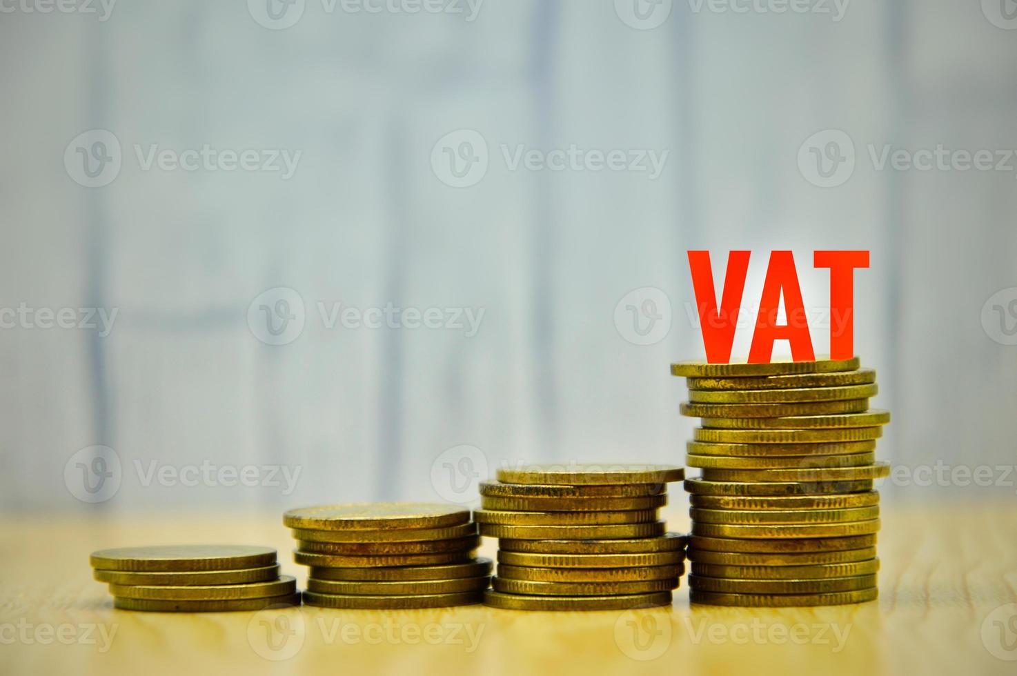IVA rojo sobre monedas de oro apiladas sobre fondo de madera plantilla de diseño negocio finanzas ingresos bancarios salario foto