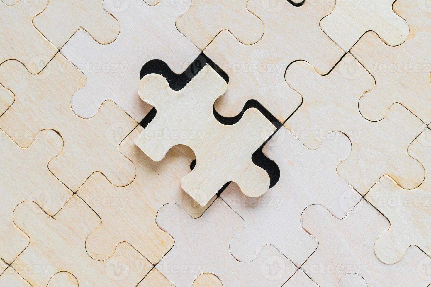Close up wooden jigsaw puzzle pieces on black background photo