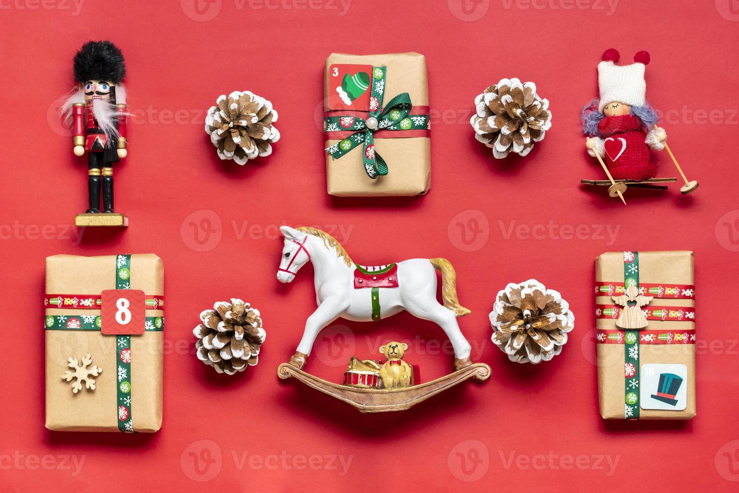 cajas de regalo rojas y verdes envueltas a mano decoradas con cintas, copos de nieve y números, adornos navideños y decoración en la mesa concepto de calendario de adviento de navidad vista superior banner de tarjeta navideña plana foto