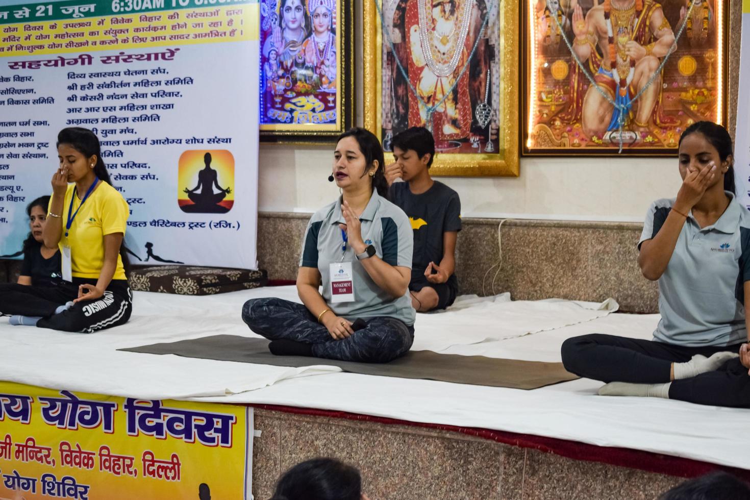 New Delhi, India, June 19 2022 -Group Yoga exercise session for people of different age groups in Balaji Temple, Vivek Vihar, International Yoga Day, Big group of adults attending yoga class in temple photo