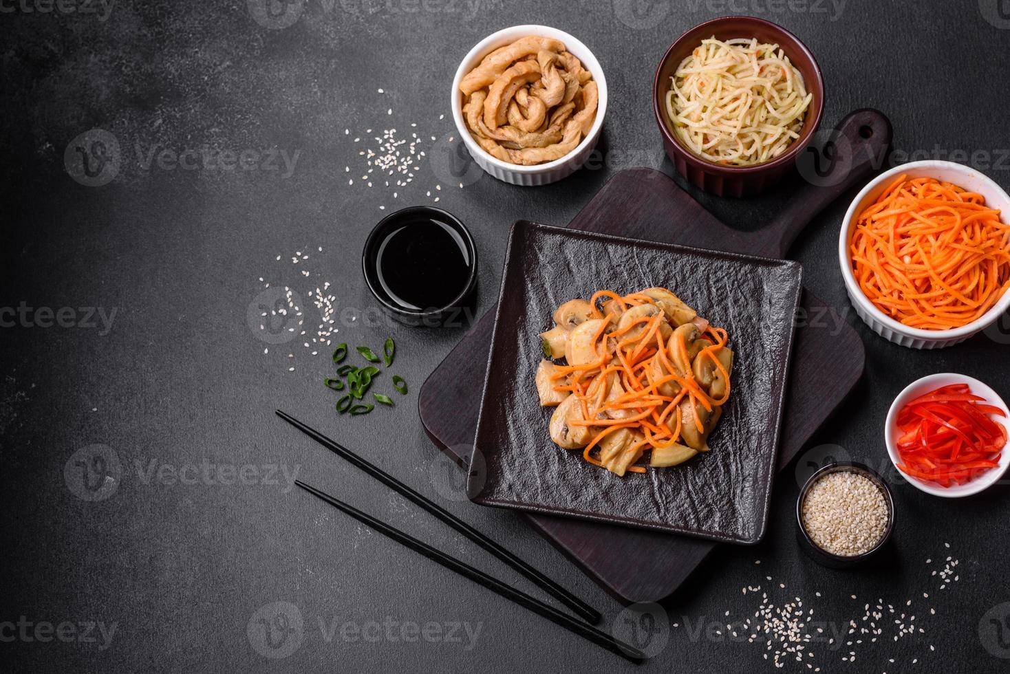 Tasty spicy Korean mushroom with spices and herbs on a dark concrete background photo