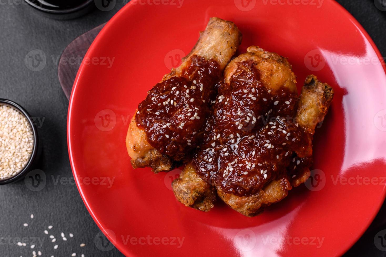 Tasty spicy chicken legs with teriyaki sauce and sesame seeds photo