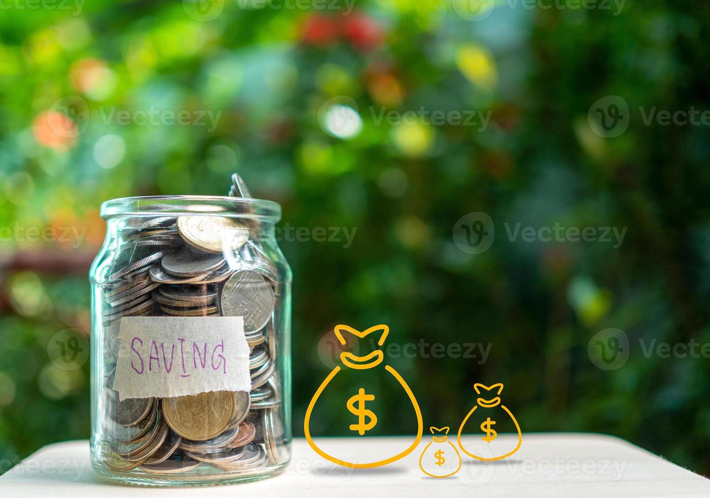 Coins in glass bottles on nature background. The concept of savings and investment. photo