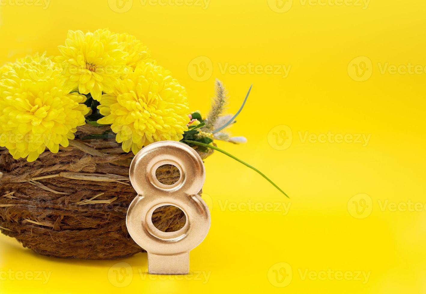 Golden number 8 near jute vase with chrysanthemums on yellow background. Holiday, March 8, International Women's Day, Birthday. Copy space photo