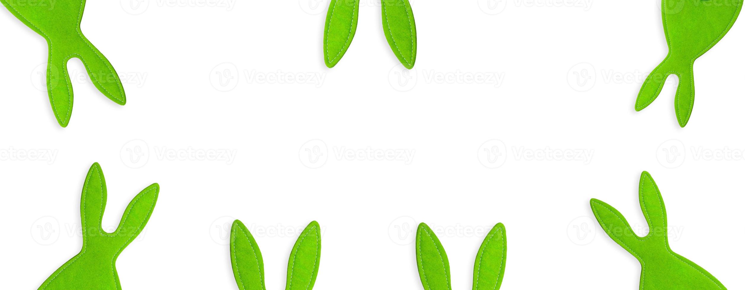 Stitched green rabbits peeking out on white isolated background. Banner, holiday, symbol of Easter, New year. Copy space photo