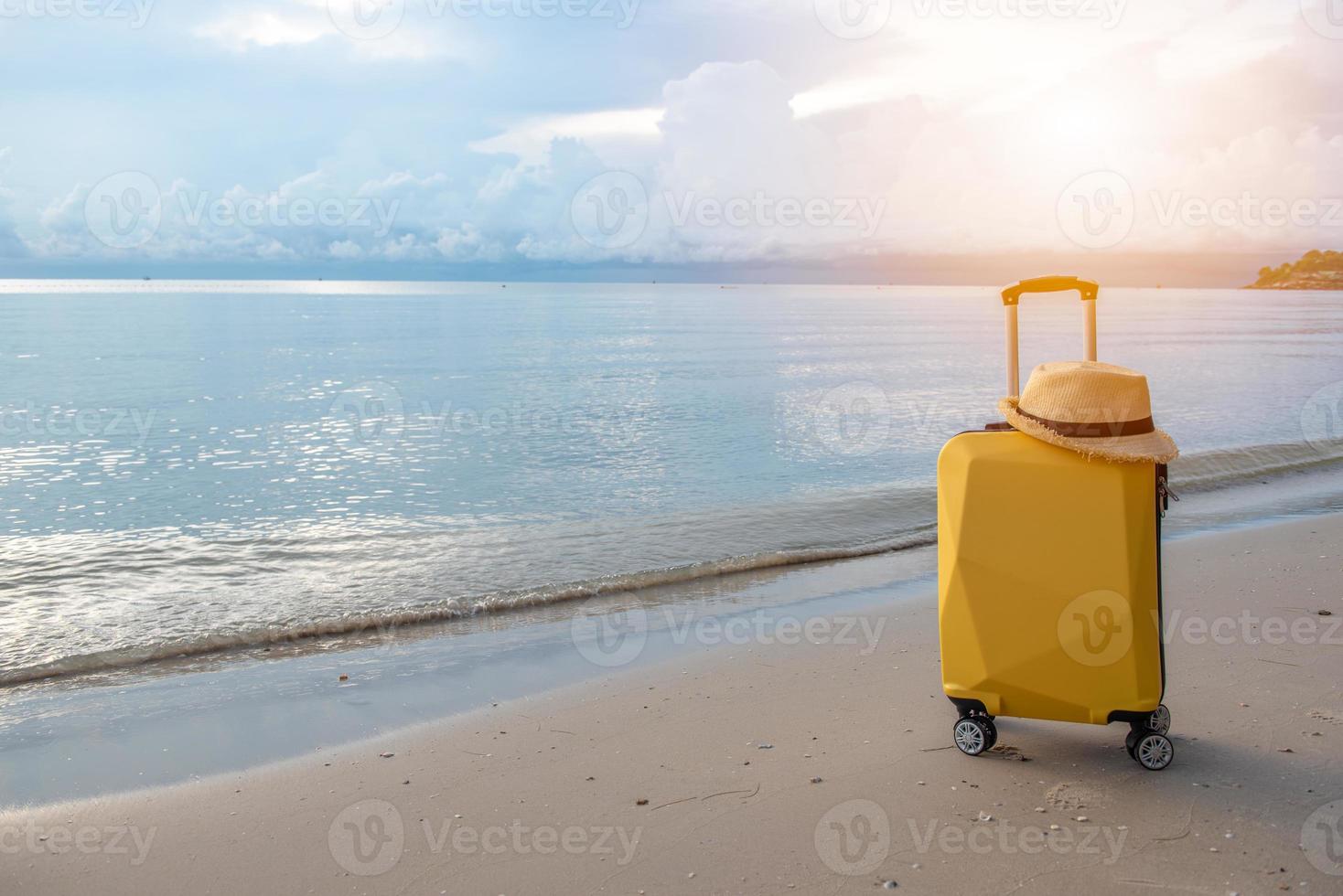 Traveling suitcase with hat on the beach, traveling and relaxing time concept. photo