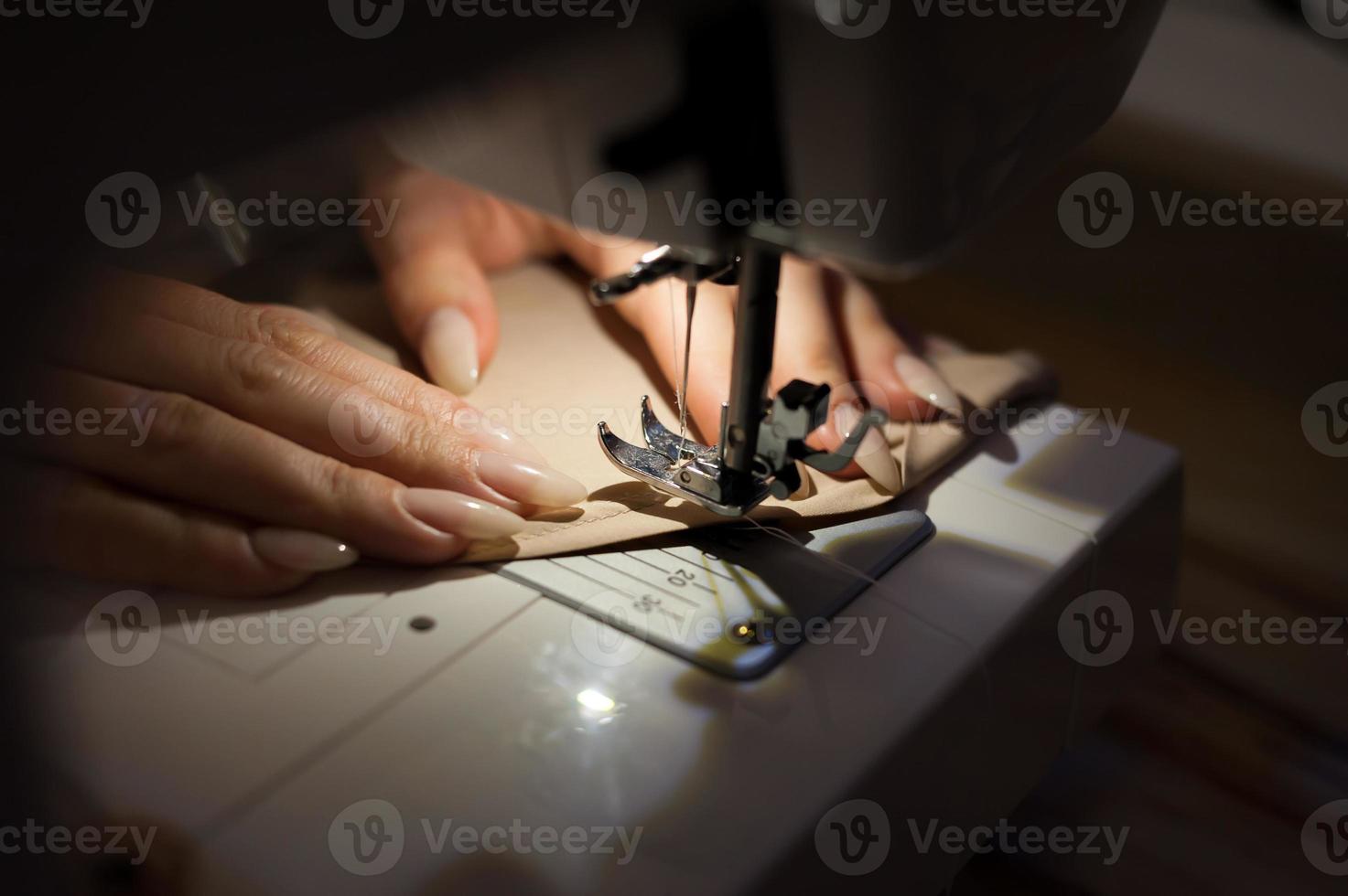 la mujer está cosiendo con máquina de coser. la costura es una de las artes textiles más antiguas. foto