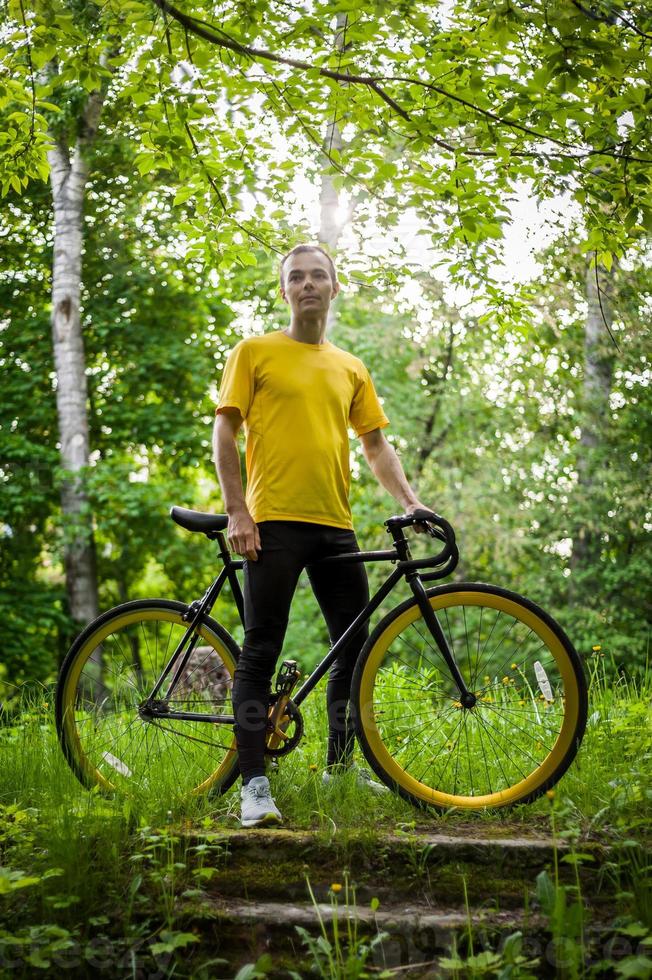 A young Man stopped to rest With his Bicycle in a public Park. photo