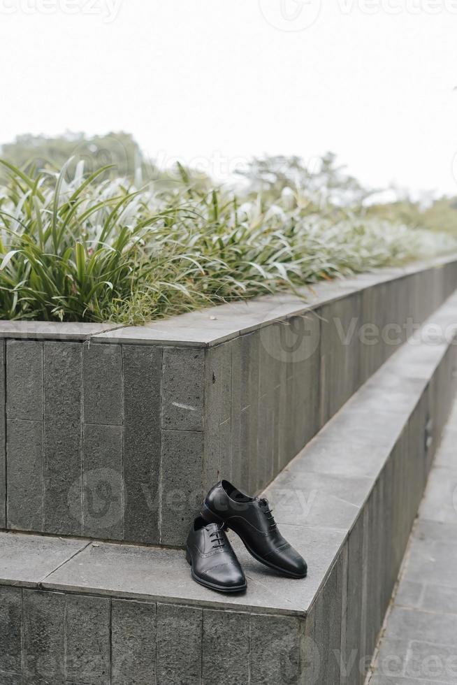 A pair of formal black gentlemen shoes laying on the ground, with negative space good for concept print. photo