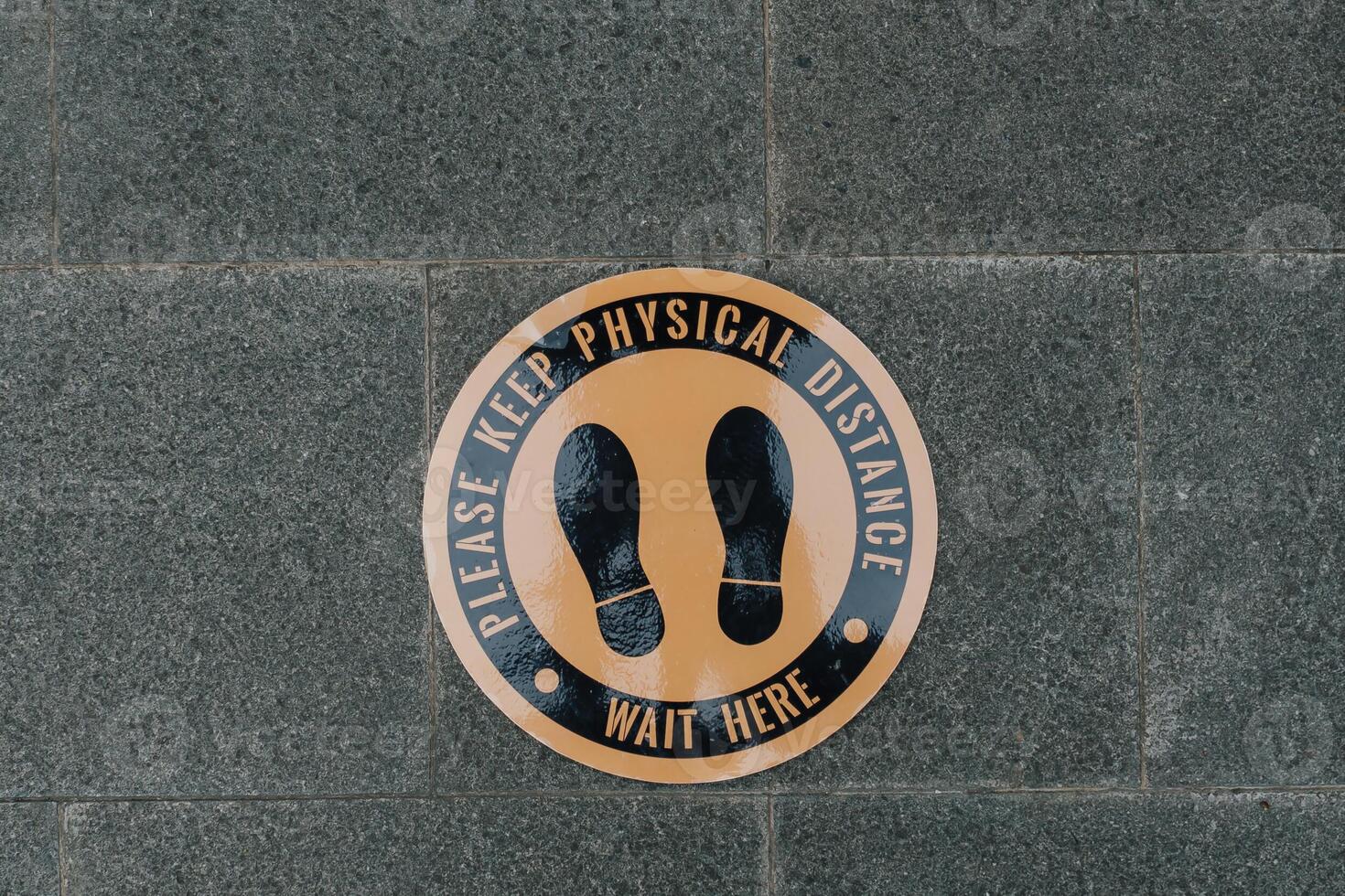 Elegant floor sign says please keep physical distance, used for health protocol in a pandemic to prevent virus. photo