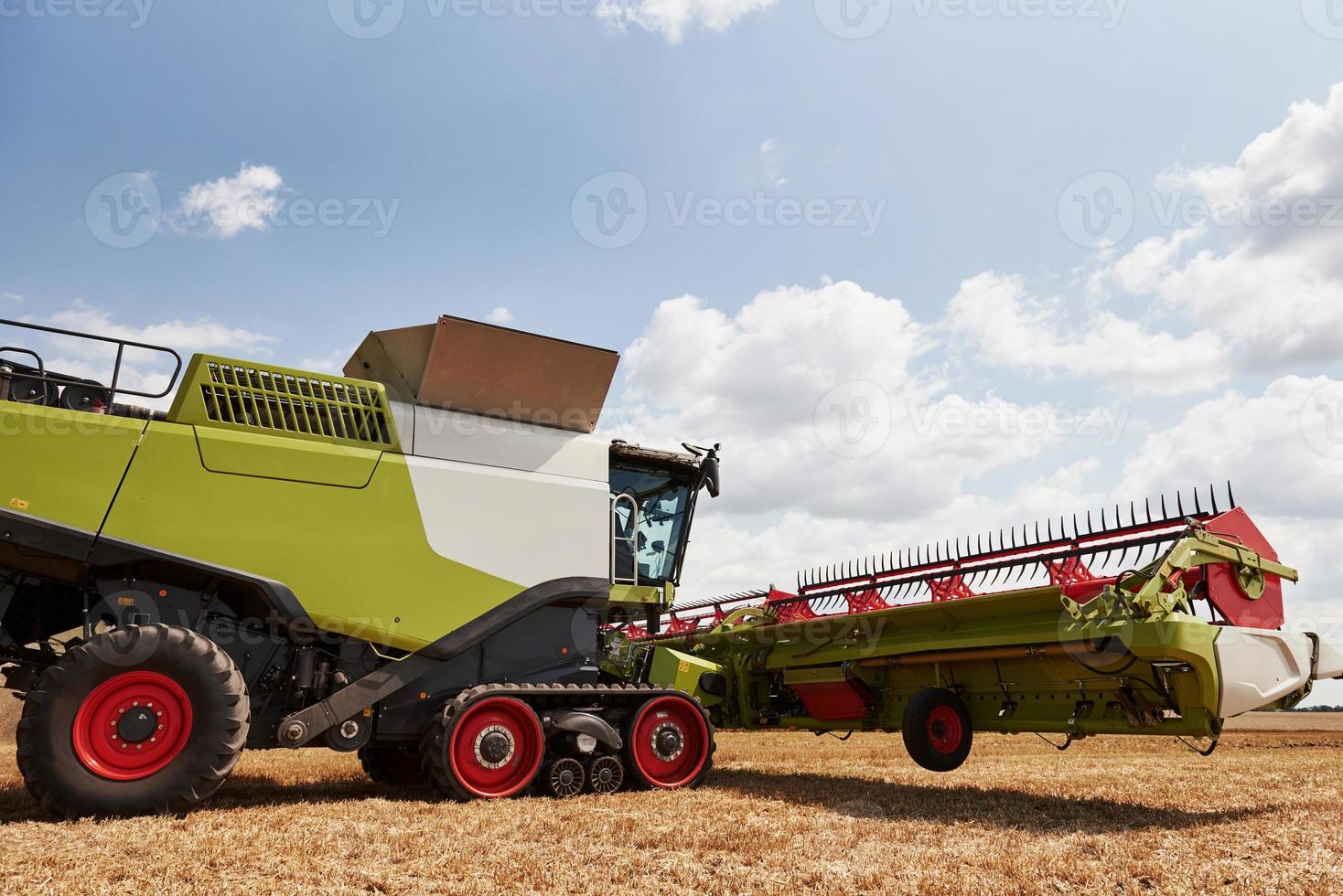 Large combine harvesters working in agriculturic field at summertime photo