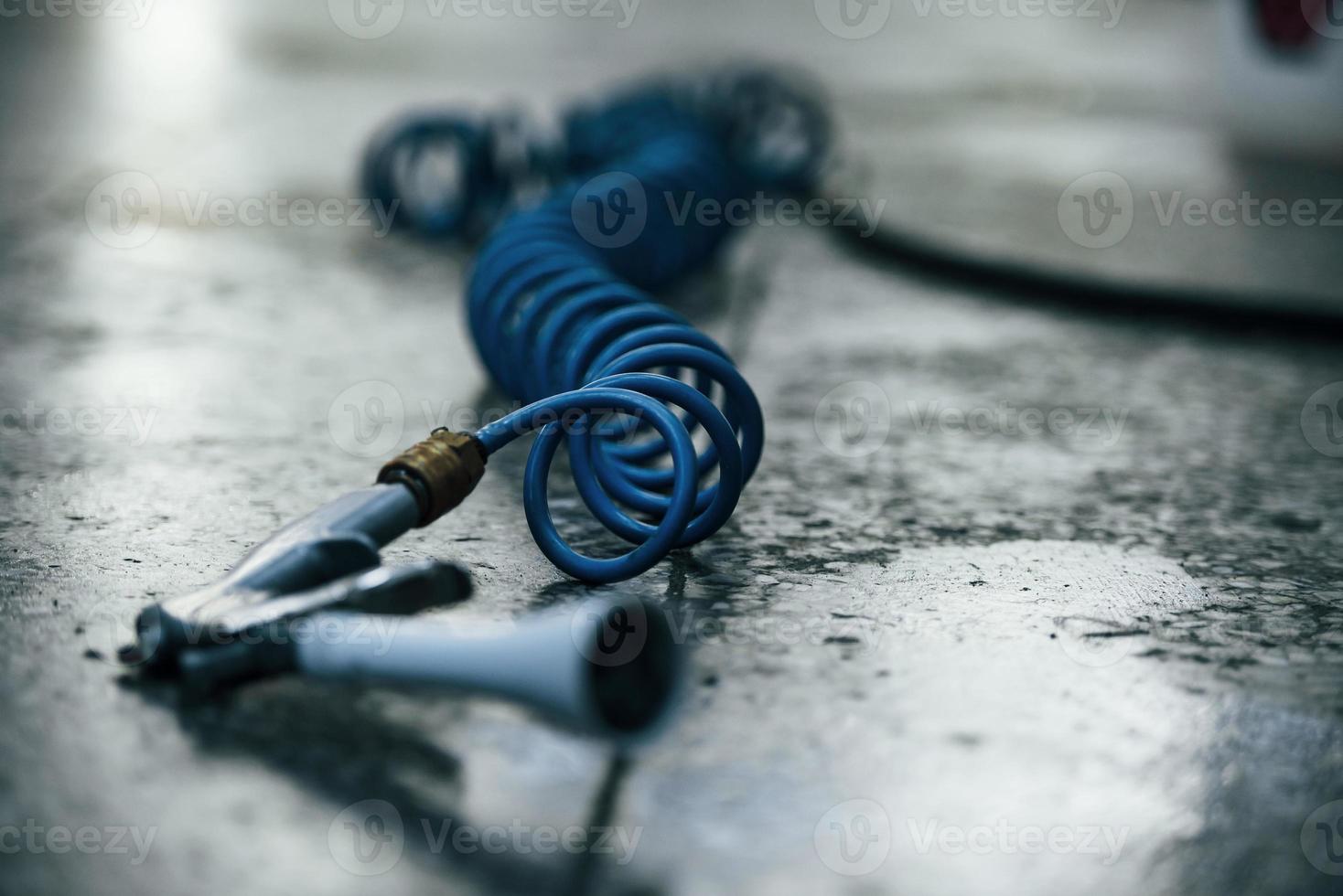 Close up view of blue car wash instrument that lying down on the ground photo
