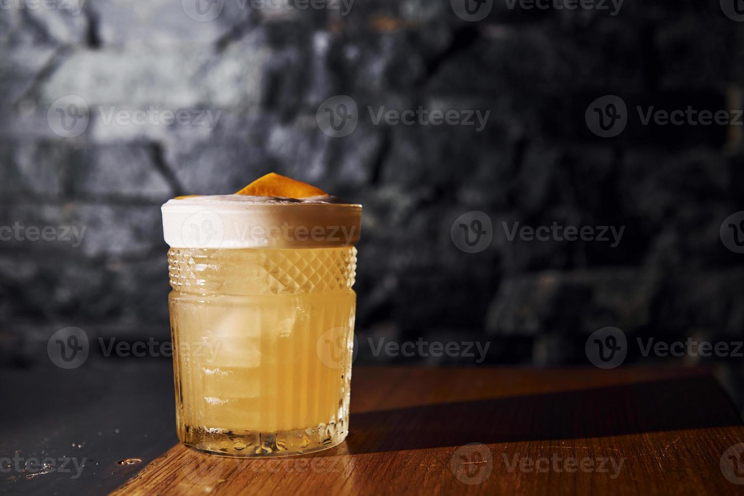 Ice cubes inside. Close up view of fresh summer cocktail on the wooden table photo