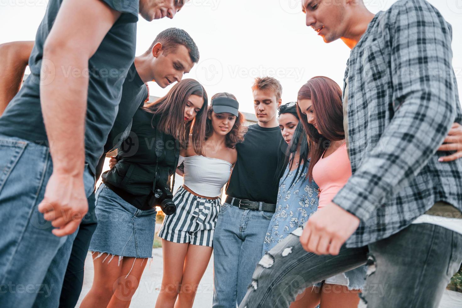 Talking and laughing. Group of young cheerful friends having fun together. Party outdoors photo