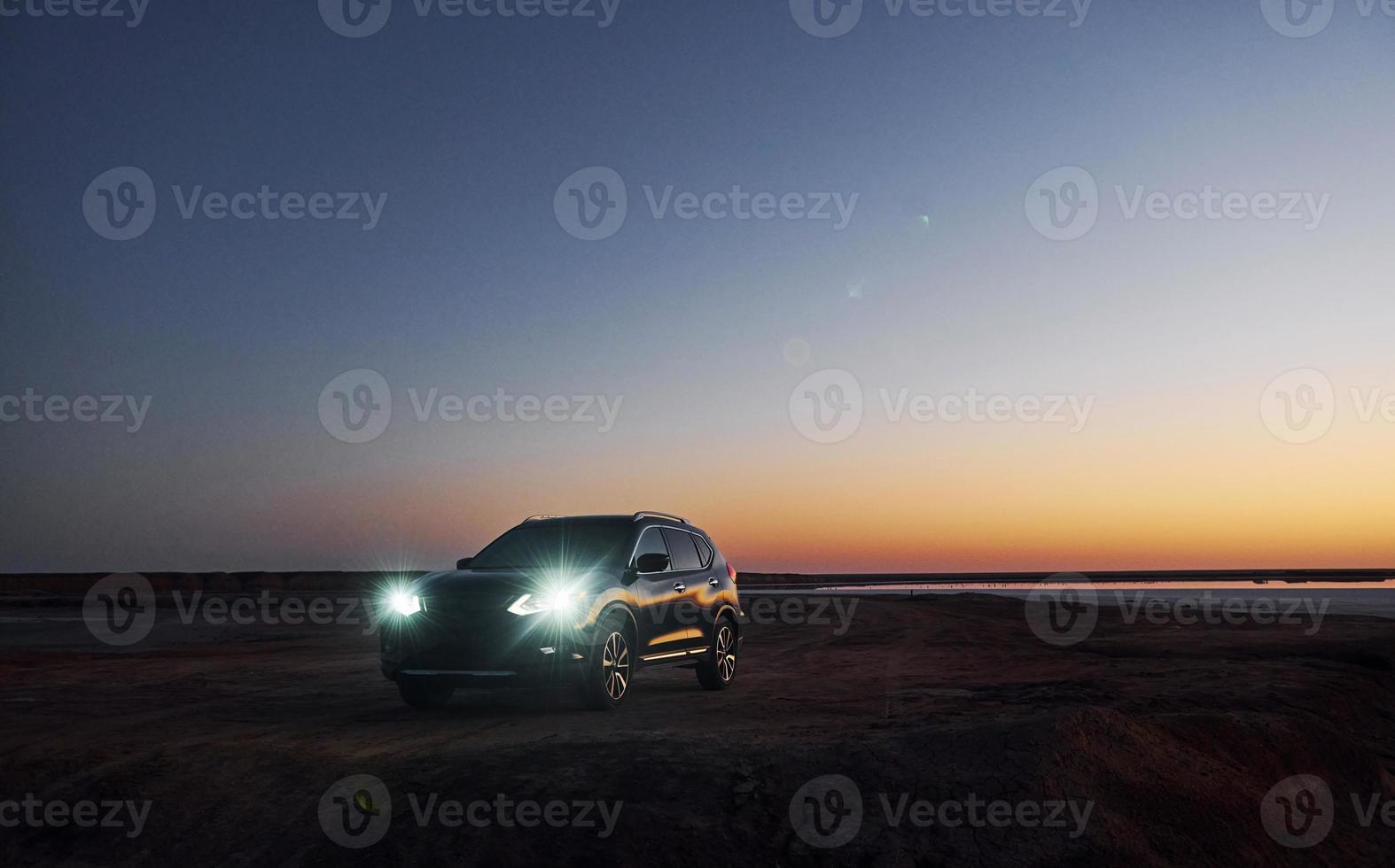 Distant view of modern black automobile that is on the coast photo