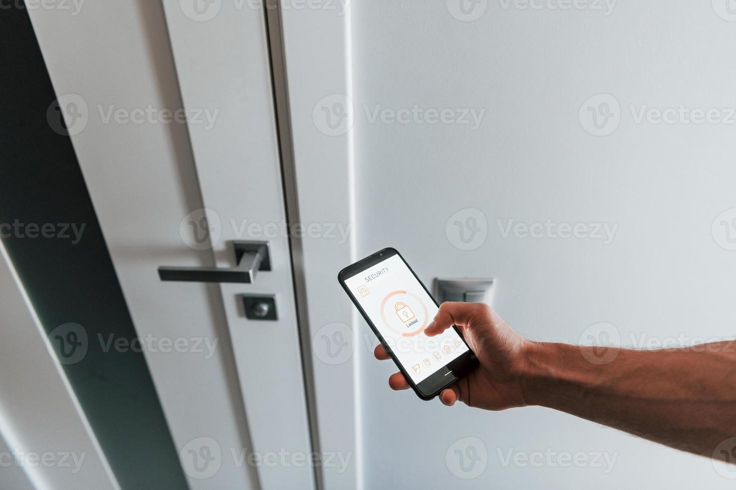 Close up view of man that is indoors controlling smart home technology photo