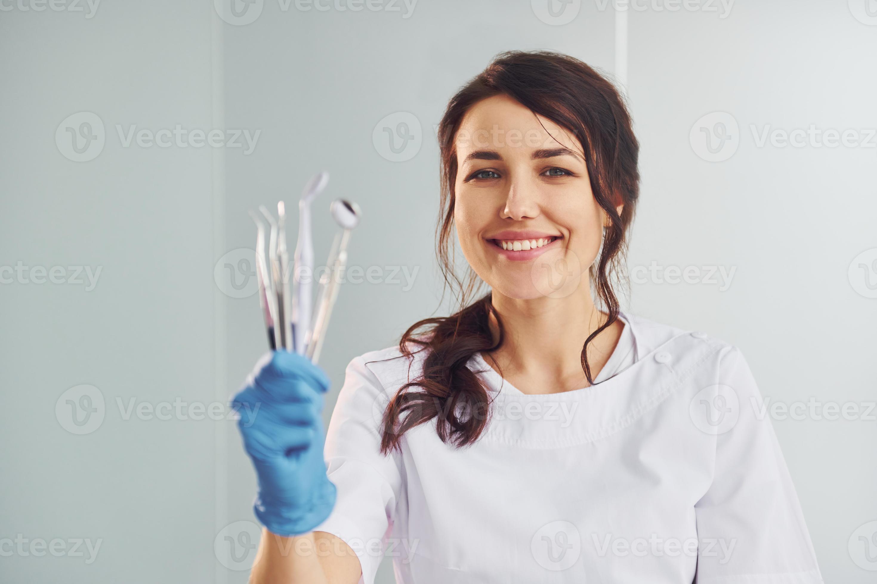 Portrait of professional female dentist with equipment that standing