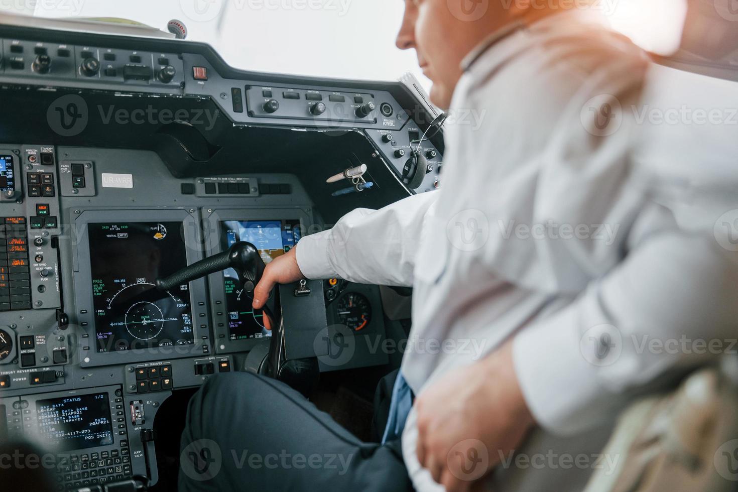 Close up view. Pilot on the work in the passenger airplane. Preparing for takeoff photo