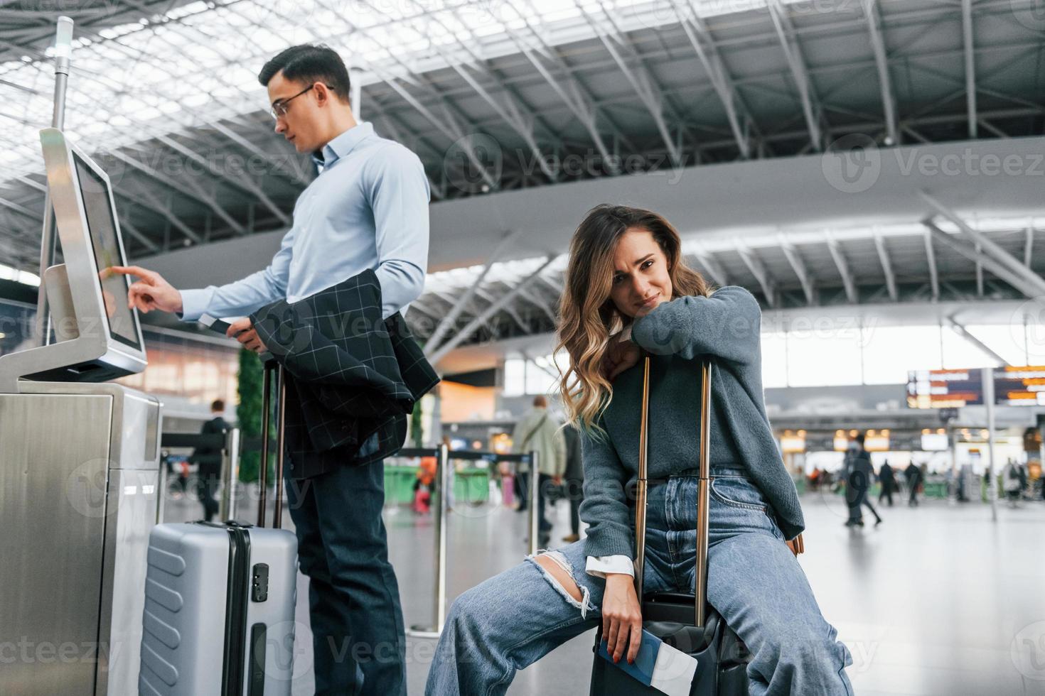 Woman is tired. Young couple is in the airport together photo