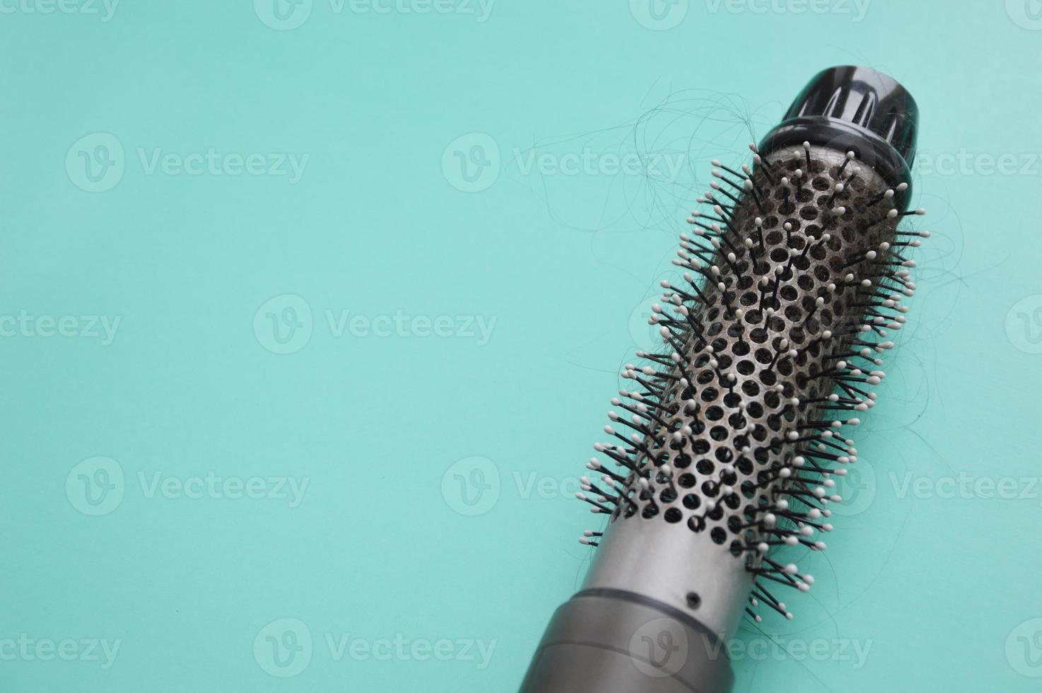 Coiled hair on an electric hair dryer after drying. Hair loss. Hairdryer with round brush. Rotating hair brush, styler, barber tool. Place for text photo