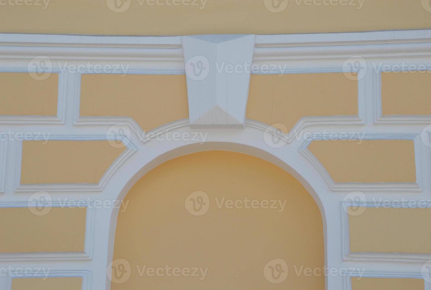 Yellow architectural element vault in the wall. The white arch is an imitation of a window. Renovated building. photo