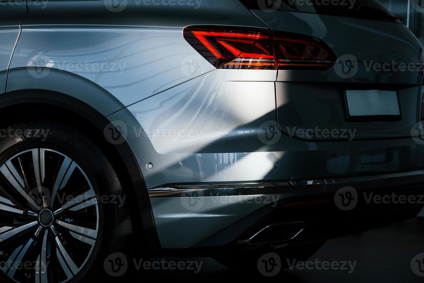 Rear part of brand new modern car. Parked at showroom. Reflection in the headlights photo