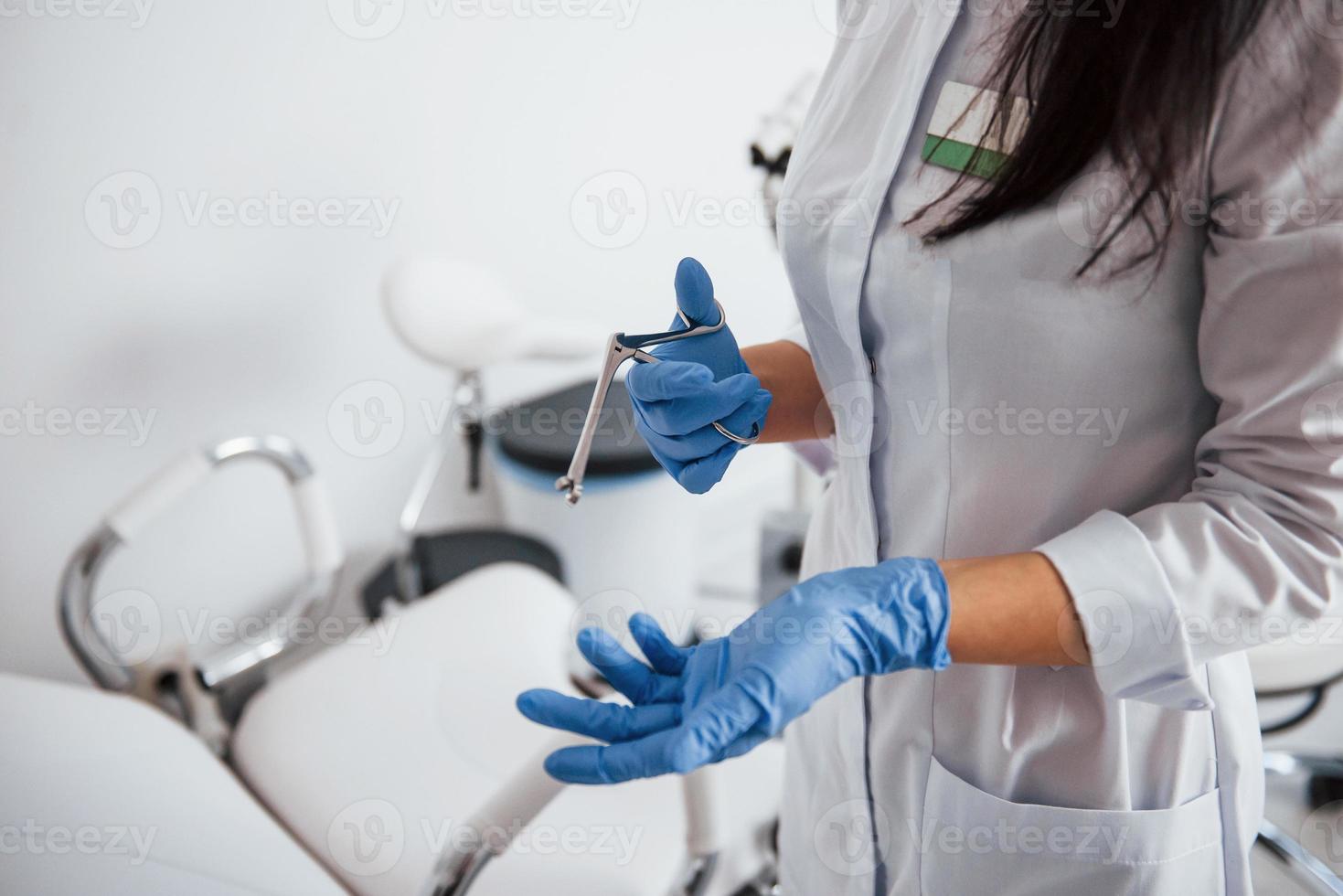 Close up view of female doctor hands that holds retractor instrument photo