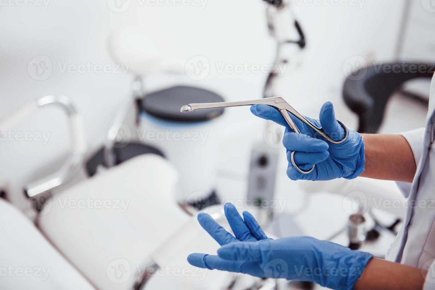 vista de cerca de las manos de una doctora que sostiene el instrumento retractor foto