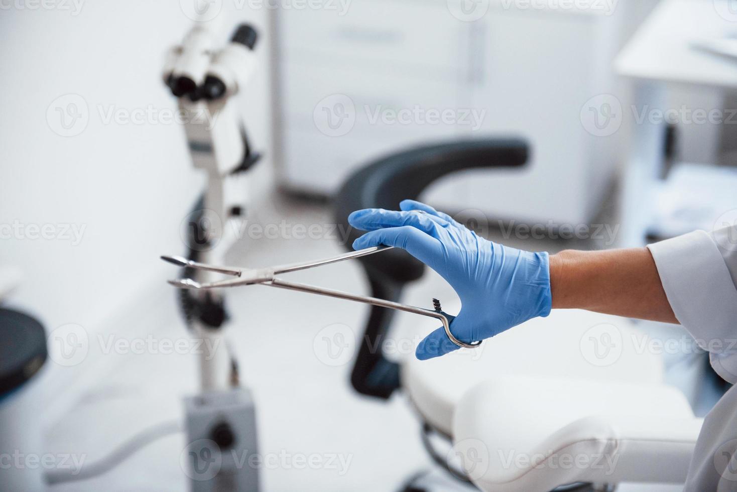 Close up view of female doctor hands that holds forceps photo