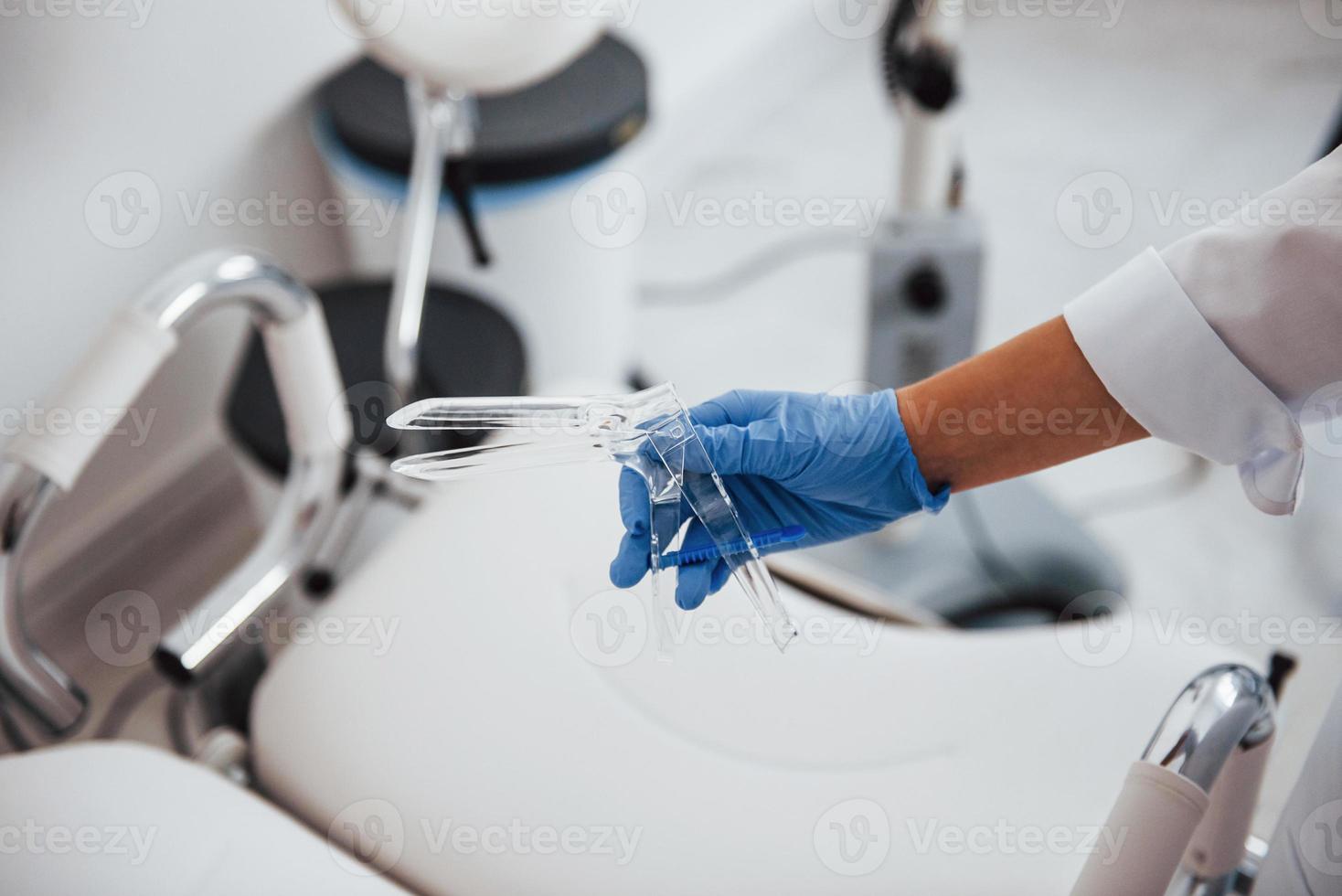 Close up view of female doctor hands that holds speculum instrument photo