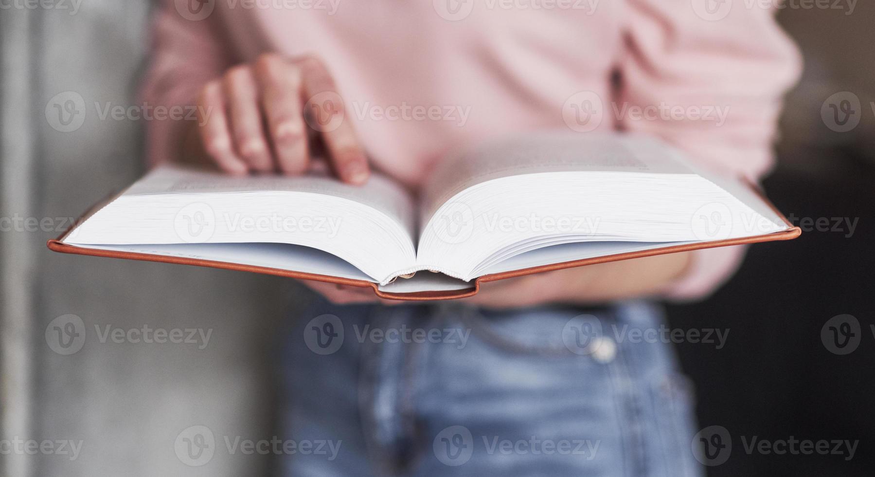 Image focus conception. Girl searching for some information in the library full of books photo