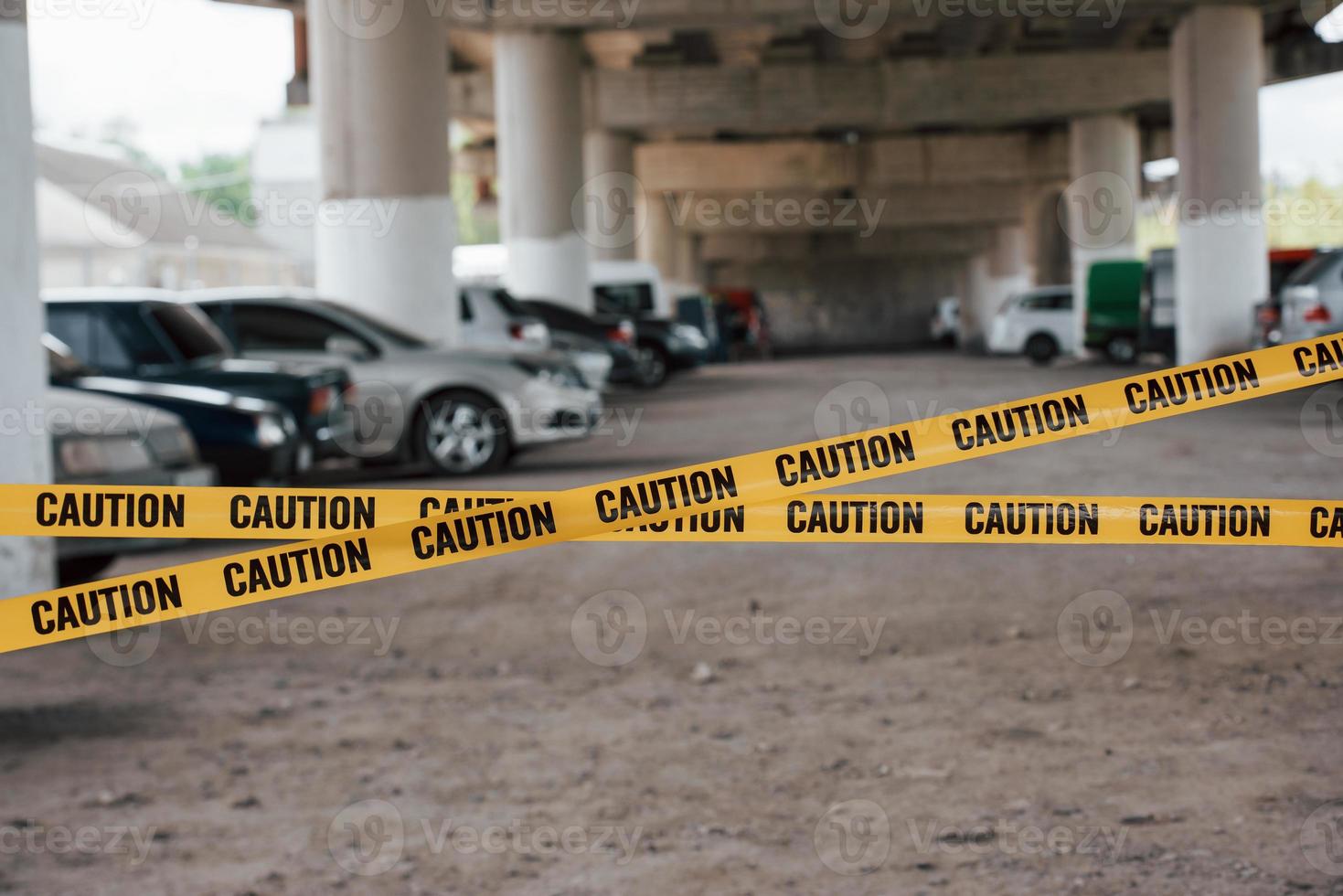 No one will enter until police take care of this. Yellow caution tape near the car parking lot at daytime. Crime scene photo