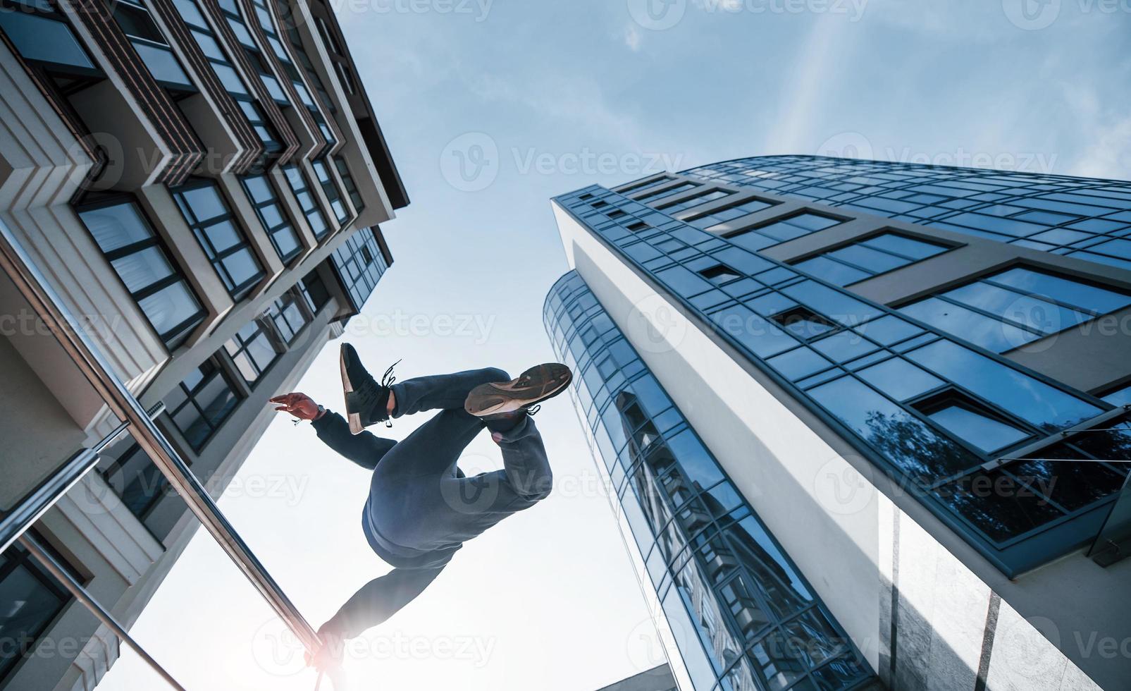 Young man doing parkour in the city at daytime. Conception of extreme sports photo