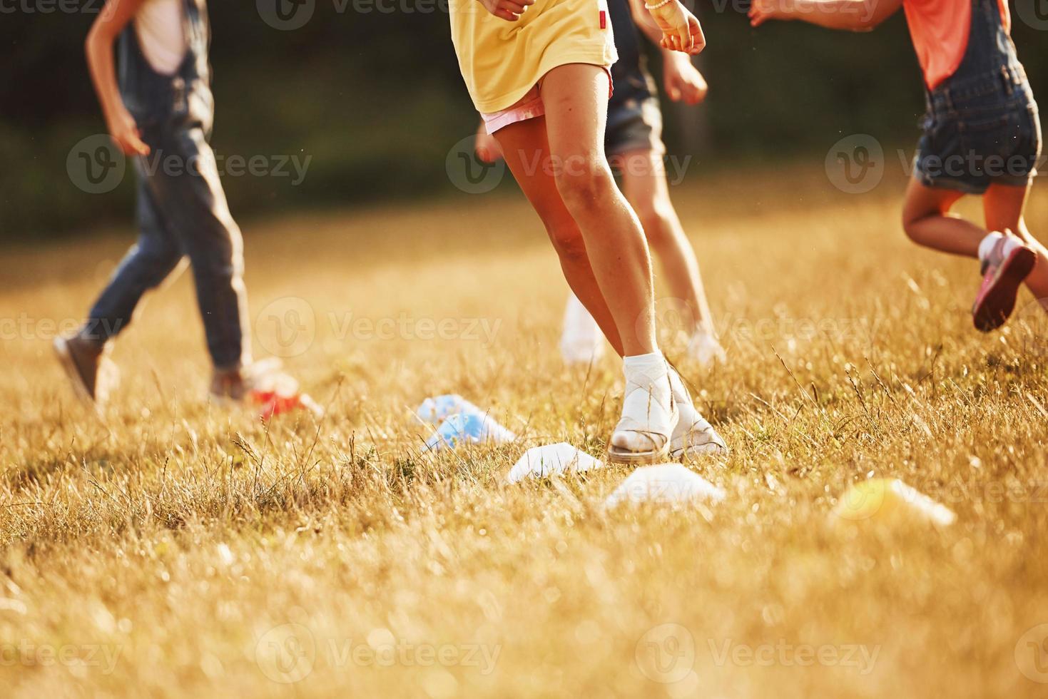 a través de obstáculos. niños corriendo en el campo en un día soleado. concepto de estilo de vida saludable foto
