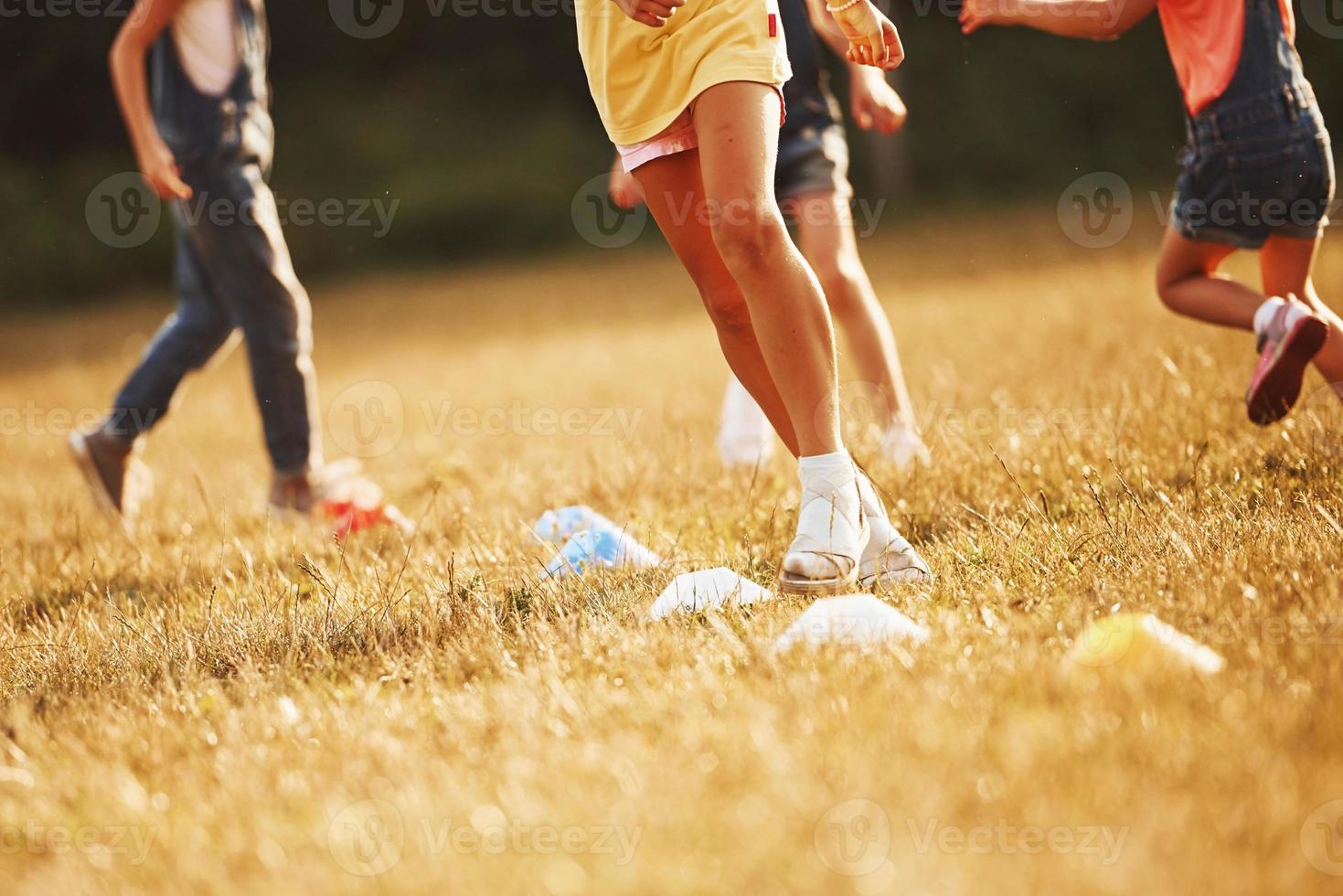 Through obstacles. Kids running in the field at sunny day. Conception of healthy lifestyle photo