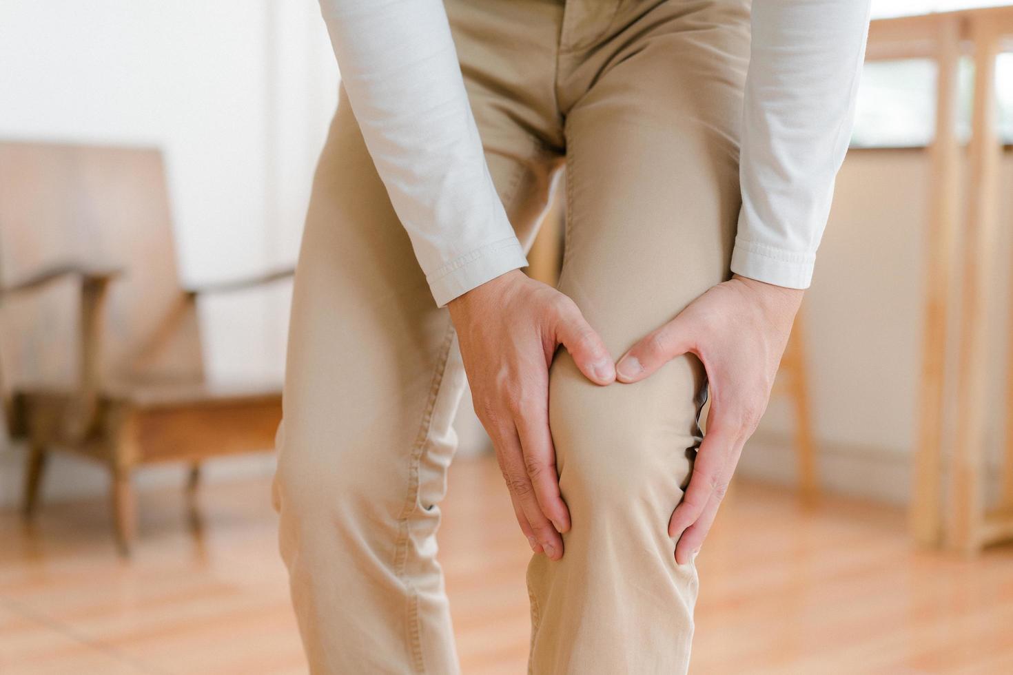man suffering from pain in knee at home, closeup , healthcare concept photo