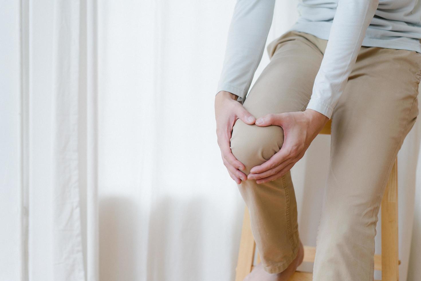 man suffering from pain in knee at home, closeup , healthcare concept photo