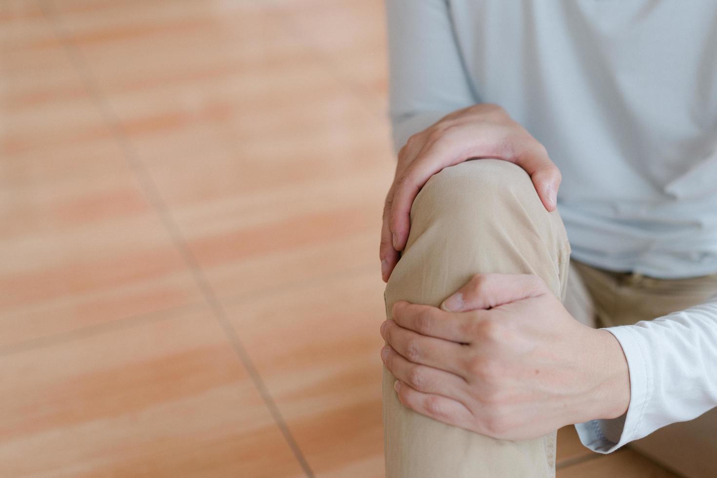 man suffering from pain in knee at home, closeup , healthcare concept photo