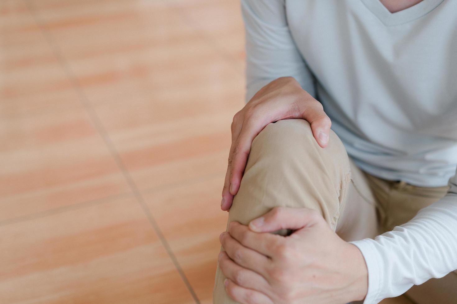 man suffering from pain in knee at home, closeup , healthcare concept photo