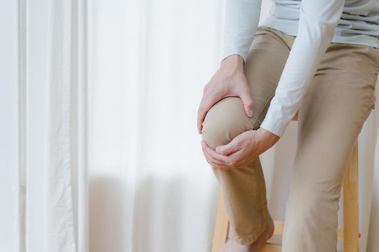 man suffering from pain in knee at home, closeup , healthcare concept photo