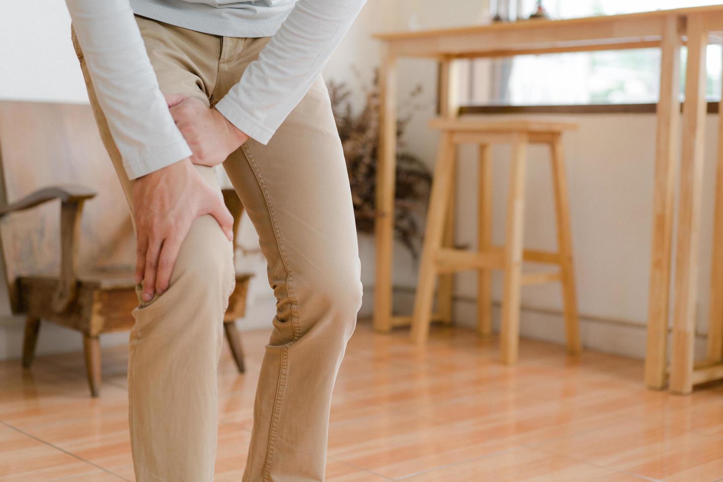 man suffering from pain in knee at home, closeup , healthcare concept photo