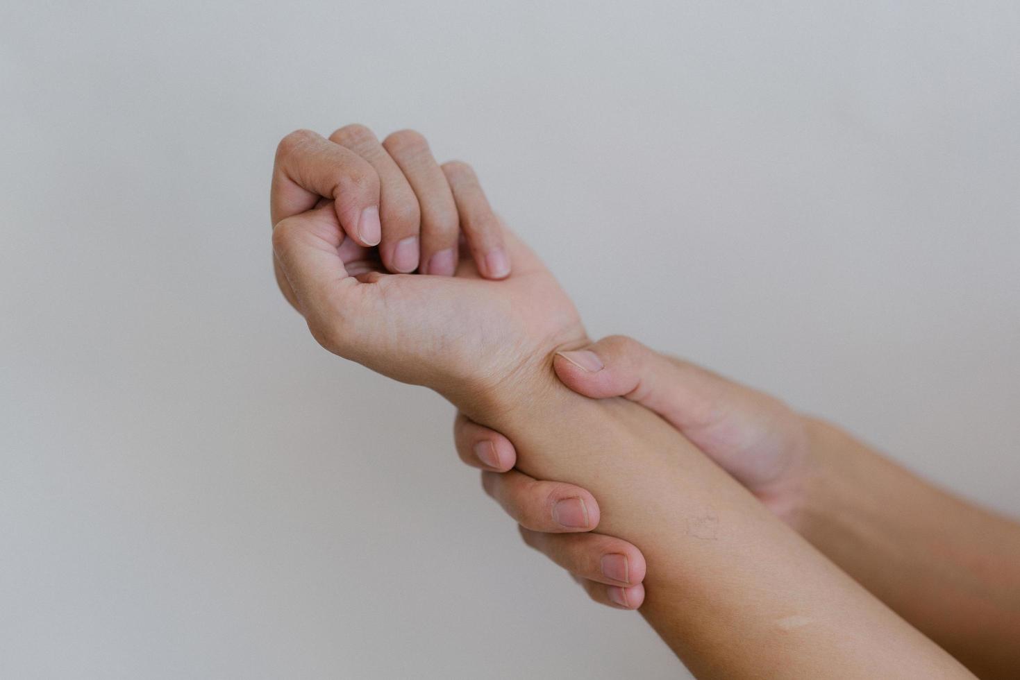 Closeup of hand with hand pain in palm isolated on gray wall background. photo