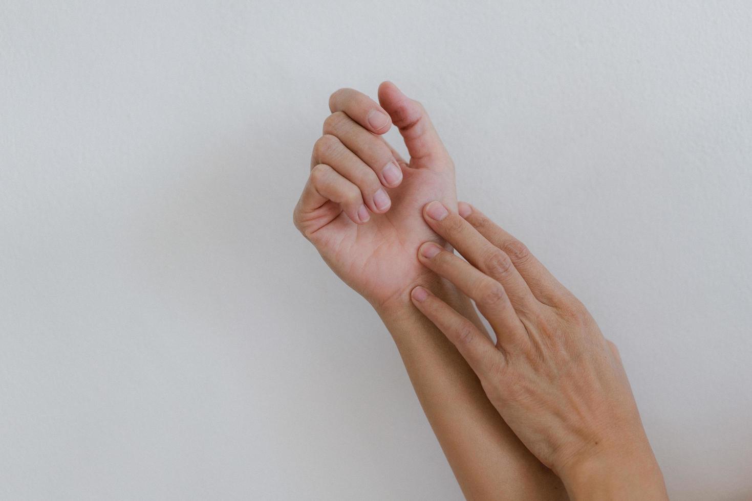 Closeup of hand with hand pain in palm isolated on gray wall background. photo