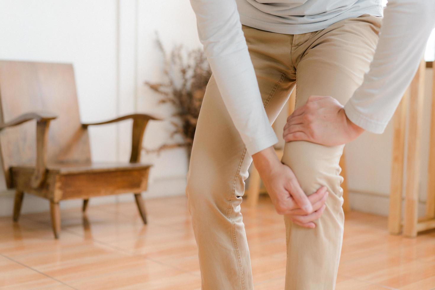 man suffering from pain in knee at home, closeup , healthcare concept photo