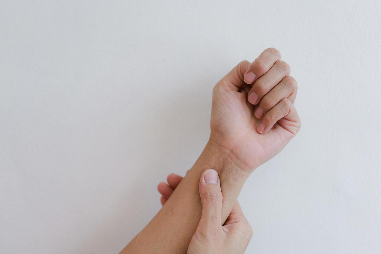 Closeup of hand with hand pain in palm isolated on gray wall background. photo