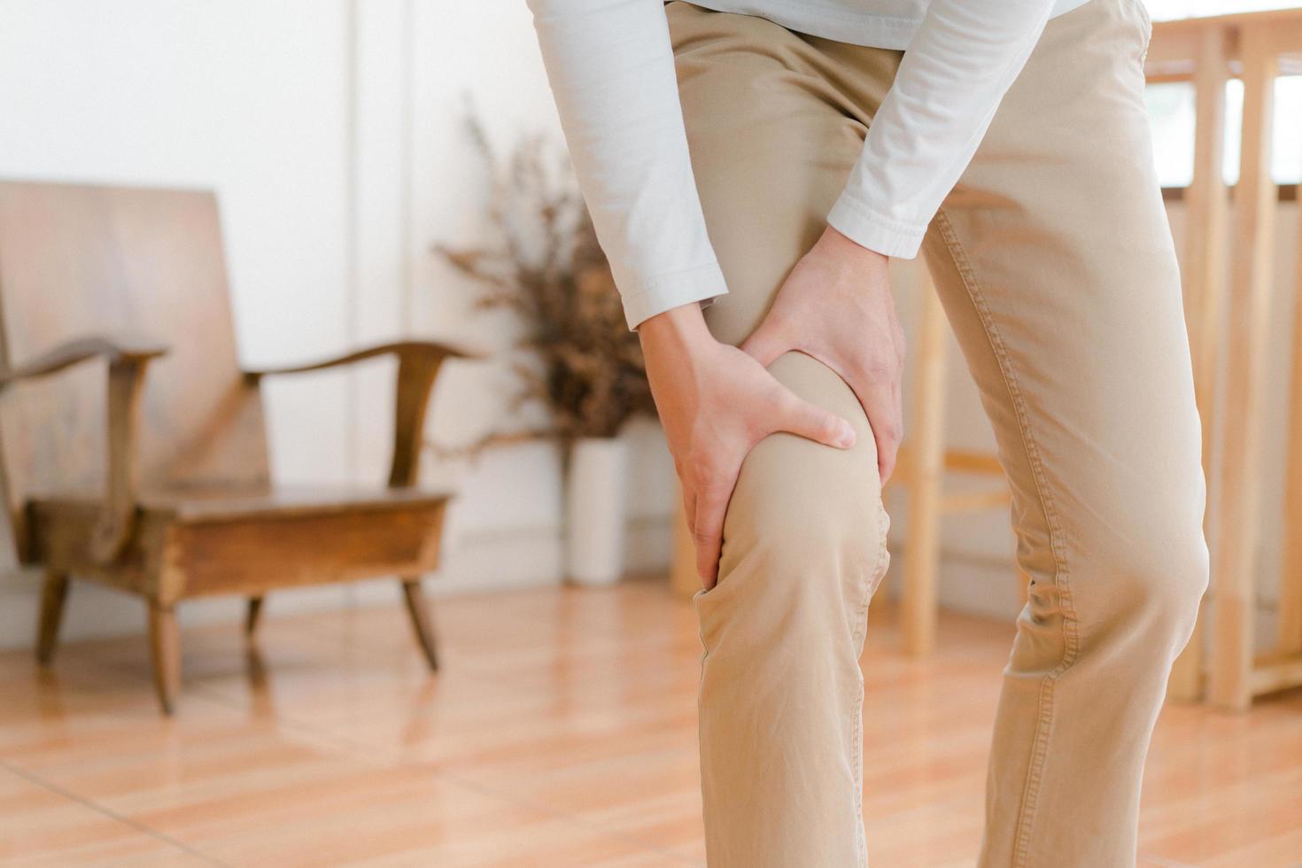 man suffering from pain in knee at home, closeup , healthcare concept photo