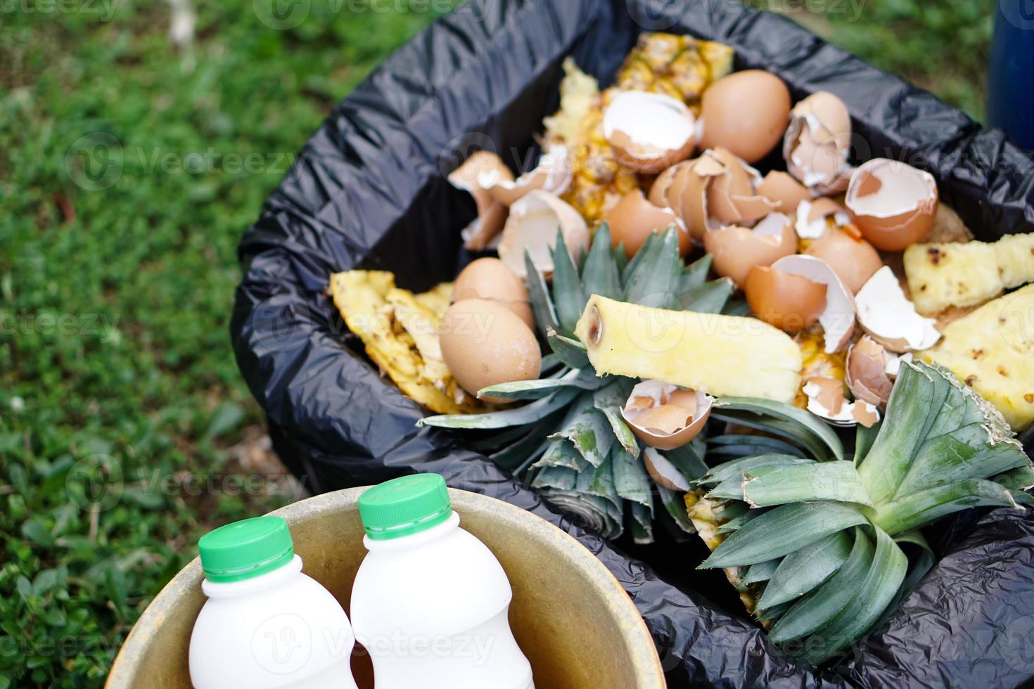 Closeup food scraps for making compost and bottles of fertilizer. Concept, Waste management. Rotten garbage from kitchen to be made compost by fermitting. Organic agriculture. photo